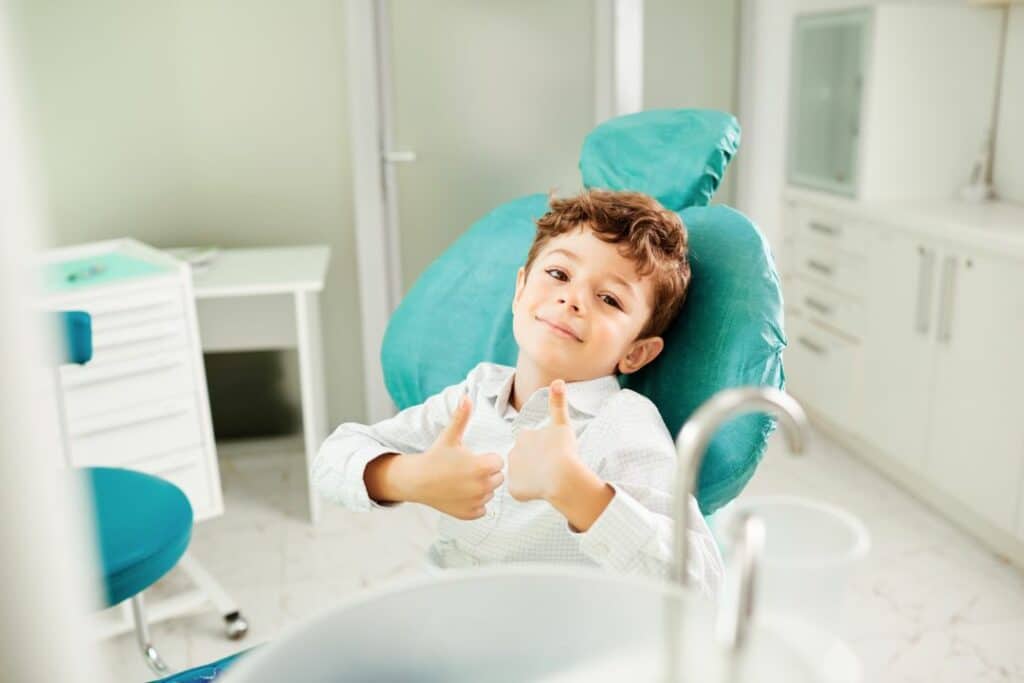 Kid sat in dentist chair with thumbs up