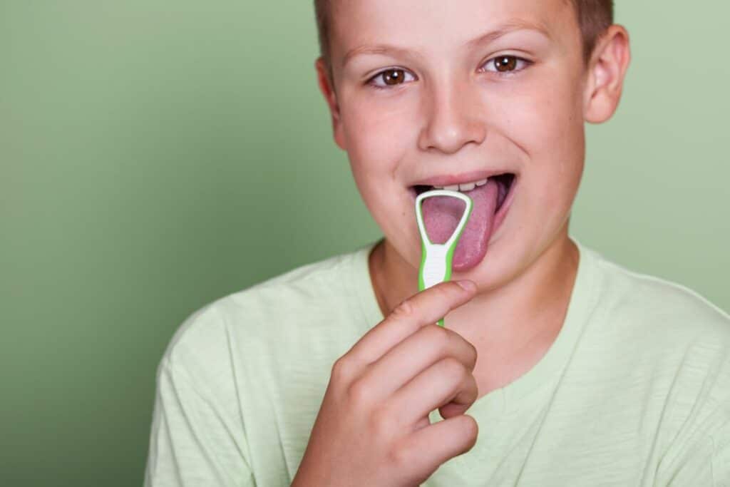 Child using a tongue scraper